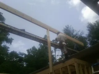 Carpenter setting a ridge beam over a new addition frame — Ice Dam Removal by Roofing Brothers in Hannibal